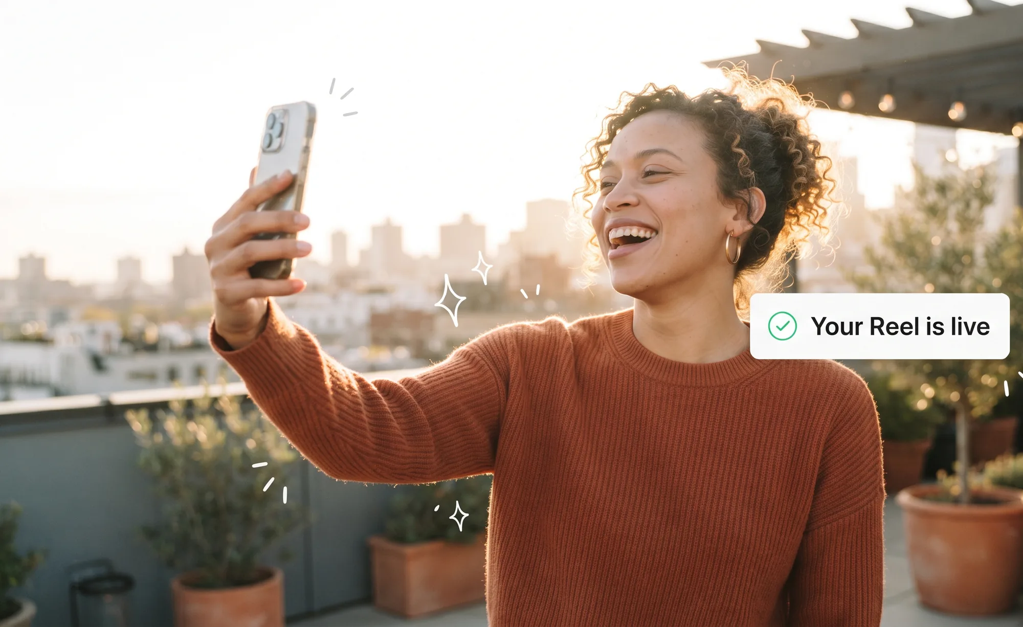 A creator on a rooftop at golden hour laughs at her phone as a notification confirms her Reel is live.